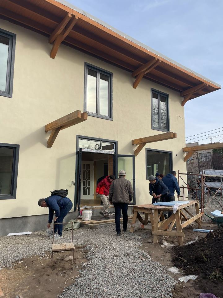 Exterior of the eco-building visited on site, with timber roof brackets